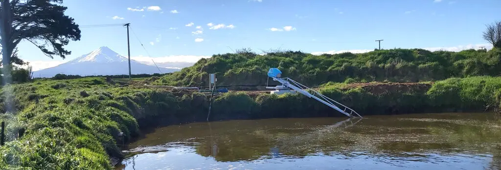 Electric vs. PTO Systems: Pros and Cons for Dairy Farm Effluent Management 3 Richard Meyer's new Nevada Electric Stirrer in a clay lined pond infront of Maunga Taranaki